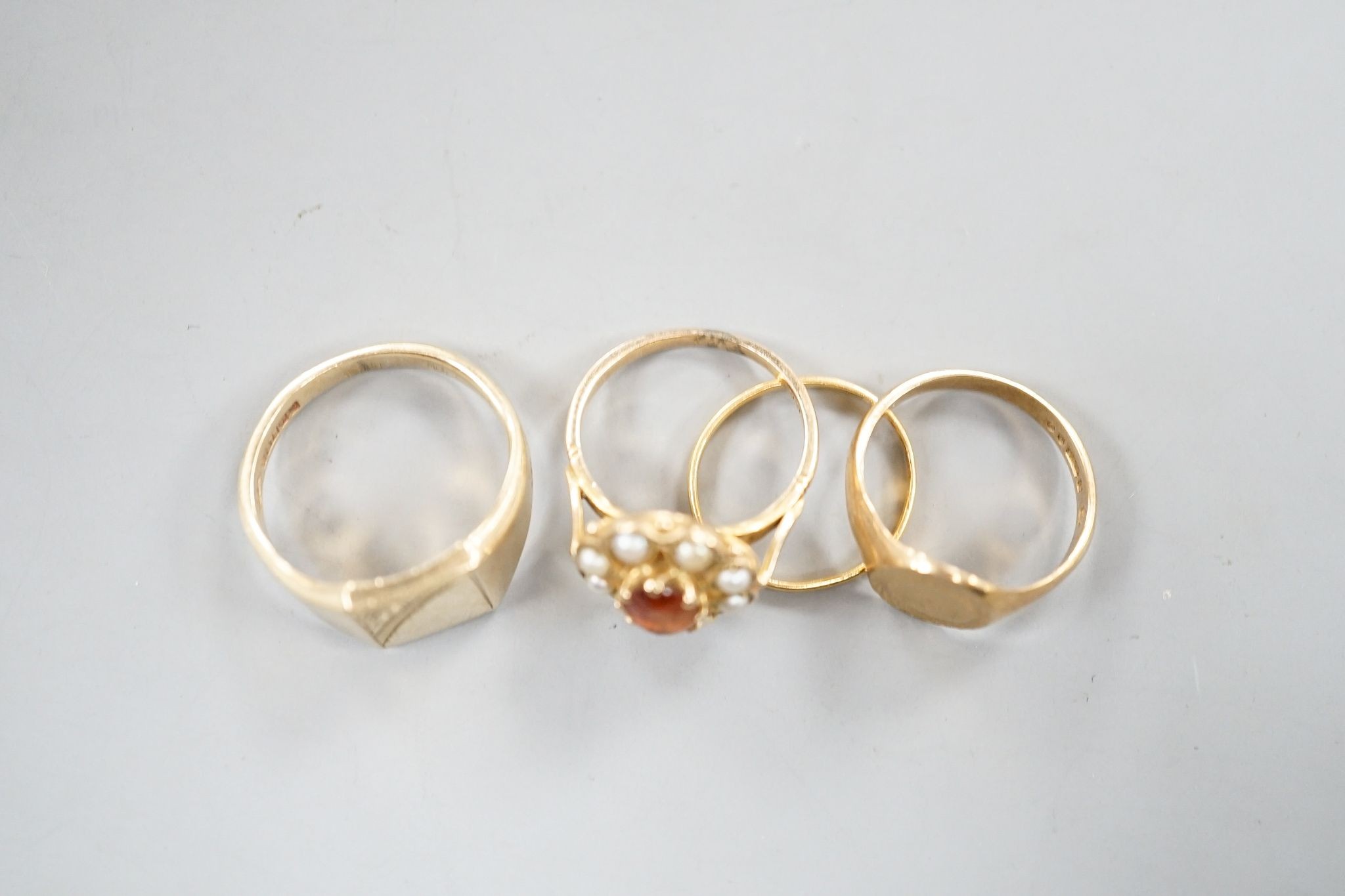 A 22ct gold wedding band, size J, 1 gram, two 9ct gold signet rings and a 9ct and gem set ring, gross 13.5 grams.